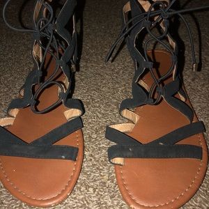 Black sandals with zig zag straps and tie up strings